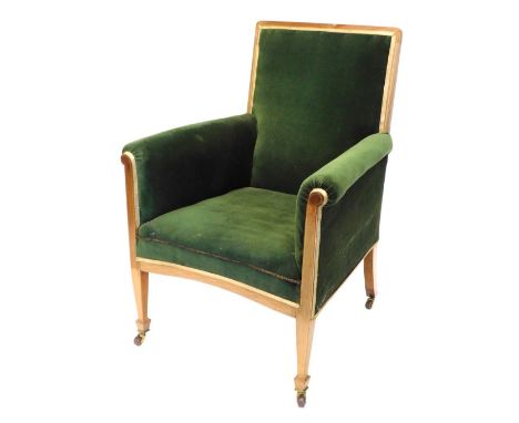 An Edwardian mahogany boxwood strung armchair, upholstered in green fabric, on square tapering legs with ceramic castors.