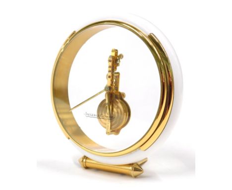 A Jaeger-Lecoultre mystery desk clock, with circular body and white and gilt coloured outer case, 16cm high, with certificate