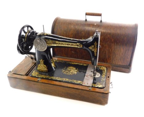 An early 20thC Singer manual sewing machine, in domed oak case, 36cm high.