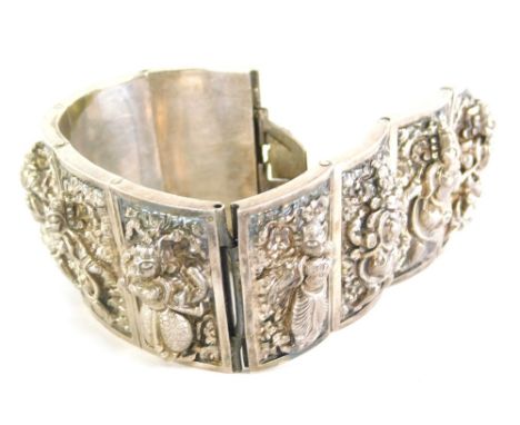 An Eastern inspired bracelet, of graduated form, with nine rectangular panels, each depicting a goddess, white metal, unmarke