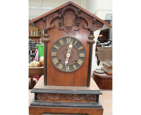 A Cuckoo clock, with a pointed arched top above a circular dial and box base with bracket feet the movement stamped Junghans 