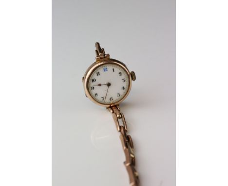 9ct rose gold cased wristwatch, white enamel dial, black Arabic numerals, gold poker hands, broken 9ct gold spring link strap