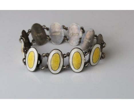 Early 20th century enamelled silver panel bracelet, eleven oval yellow and white enamelled panels, chain links, tongue and bo