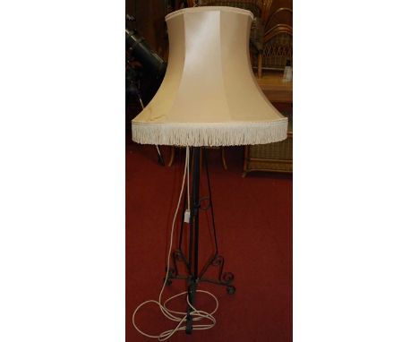 A black painted wrought iron standard lamp, with silk shade