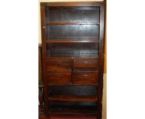 A contemporary hardwood freestanding open display shelf having four short central drawers, width 100cm