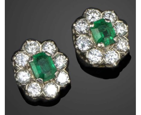 A pair of emerald and diamond cluster earrings, set with emerald-cut emeralds within a surround of diamonds in white gold, sc