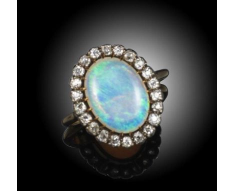 An opal and diamond cluster ring, the oval opal cabochon set within a surround of old cushion-shaped diamonds in silver and g