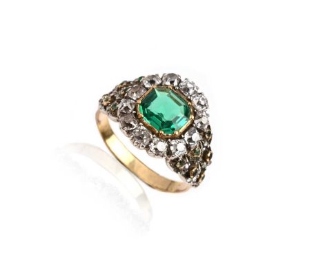 An early 19th century emerald and diamond cluster ring, the octagonal-cut emerald set within a surround of twelve cushion-sha