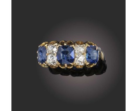 A sapphire and diamond half-hoop ring, the three old cushion-cut sapphires alternately-set with pairs of old cushion-cut diam