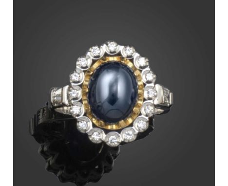 A sapphire and diamond cluster ring, the central oval cabochon sapphire set in yellow gold, within a surround of round brilli