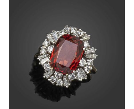 A garnet and diamond cluster ring, the cushion-cut garnet within a ballerina surround of tapering baguette-shaped and graduat