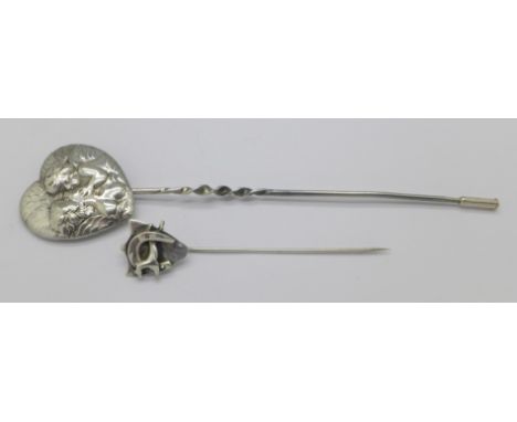 A cherub hat pin and a horseshoe stick pin