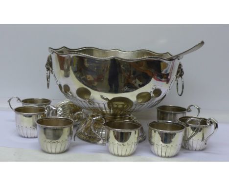 A silver plated punch bowl, ladle and eight cups