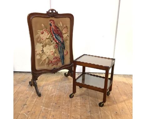 A William IV rosewood firescreen, the moulded undulating frame with floral pierced carved crest rail enclosing a floral needl