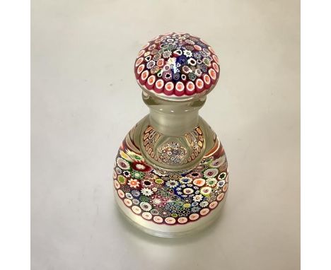 A millefiori paperweight inkwell of domed form, with concentric canes in multiple colours, cased in clear glass, rising to th