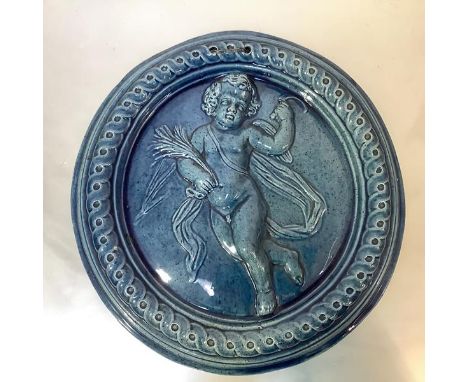 A Dunmore pottery roundel, 19th century, the turquoise-glazed plaque modelled in relief with a putto symbolic of the Autumn, 