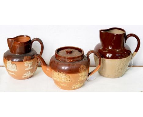 A DOULTON SALTGLAZED BROWN STONEWARE TEAPOT AND COVER AND JUG, SPRIGGED WITH HUNTING SUBJECTS AND A LARGER SIMILAR DENBY WARE