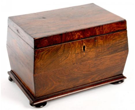 AN EARLY VICTORIAN ROSEWOOD TEA CADDY, THE DIVIDED INTERIOR RETAINING A PAIR OF COVERS, ON BUN FEET, 22CM L ++One side of the