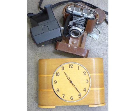 A coin slot clock, a Polaroid camera and a Barbola camera