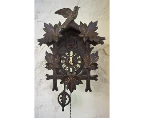 A Black Forest Style Cuckoo Clock, with cuckoo surmount above dial with Roman numerals, with two weights, (clock 45cm high)