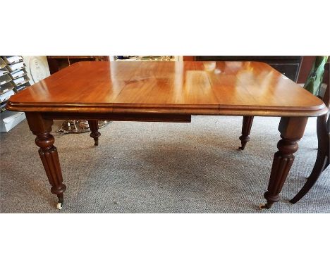 A Victorian Mahogany Wind Out Dining Table, with additional leaf, raised on reeded legs with ceramic castors, with winder, 73