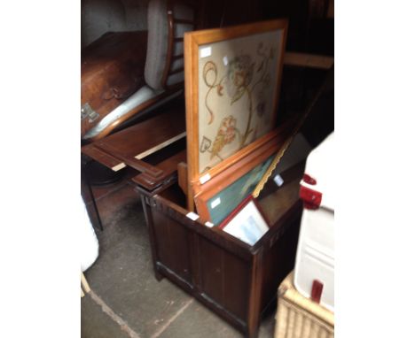 An oak bedding box containing various paintings, a mirror and a needlework firescreen/table. 