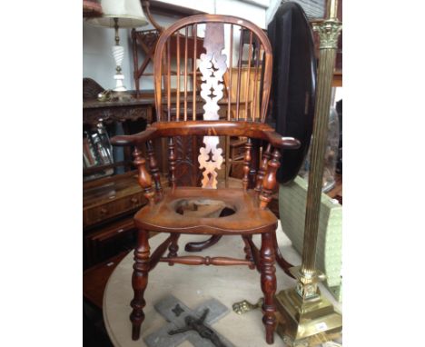 A 19th century beech and yew wood Windsor commode armchair. 