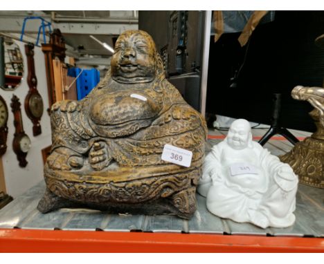 A concrete Buddha statue together with a ceramic white Buddha. 