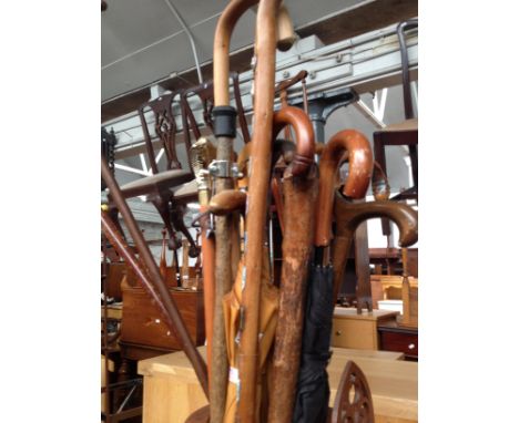A vintage stick stand with a number of walking sticks and umbrellas. 