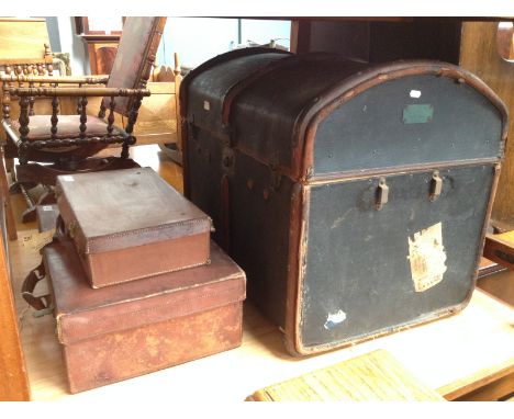 A vintage dome top travel trunk and two vintage brown leather cases. 