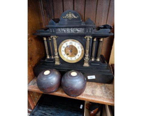 A black slate mantel clock with key and pendulum. 