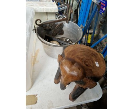 A stainless steel cooking pot, a  carved stool in the form of an elephant, a thermometer and three cast metal pieces 