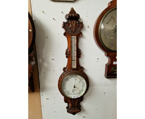 A barometer in carved oak case by Chadburns Ltd, Liverpool. 