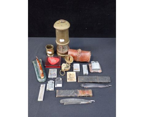 A BRASS MINER'S LAMP (UN-NAMED), LIGHTERS a compass, razors and other items