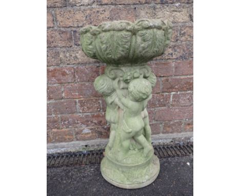 A RECONSTITUTED STONE BIRD BATH the leaf-moulded basin supported by putti 55cm high