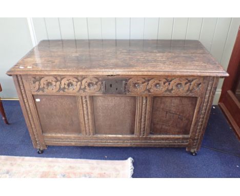 A 17TH CENTURY OAK COFFER with floral frieze and three-panel front, 127cm wide