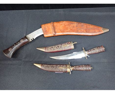 A KUKRI, POSSIBLY NEPALESE, IN LEATHER SCABBARD (note; wedged in) the blade stamped 'K45' and with broad arrow, the leather'C