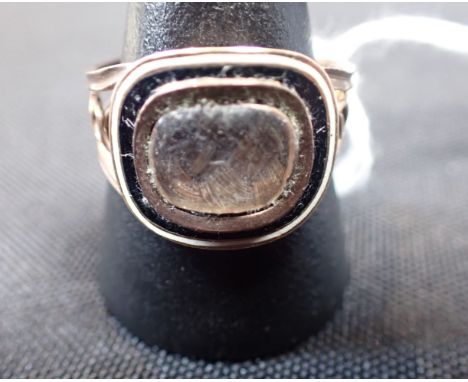 A GEORGIAN MOURNING RING woven hair decoration with gold and enamel setting, and dated May 1810