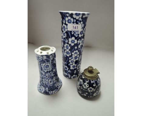 A Frederick Rhead Woods'Prunus' vase, a blue and white hat pin holder and a similar ink well with brass lid.