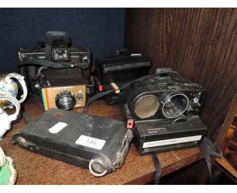 Four vintage cameras including two Polaroids