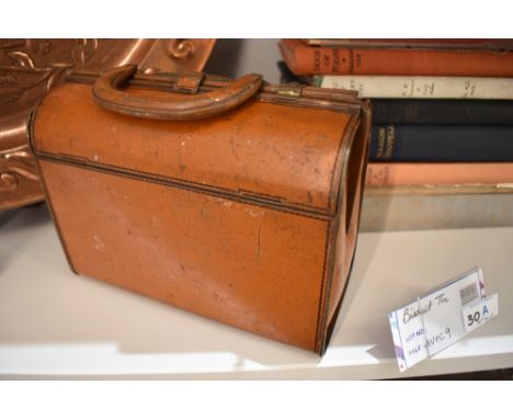 A vintage chocolate or biscuit tin in the form of a Gladstone bag.