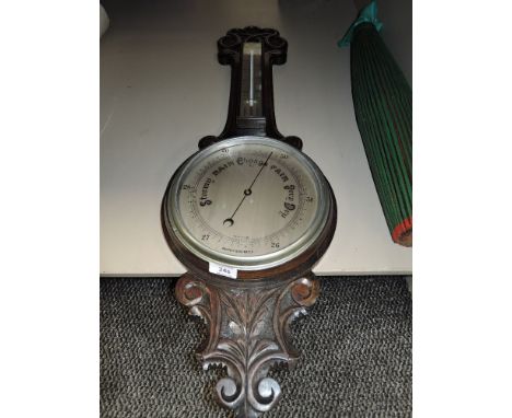 A vintage banjo style aneroid barometer having carved oak frame work