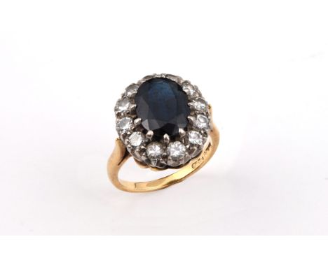 A SAPPHIRE AND DIAMOND CLUSTER RING the oval-shaped sapphire is set within a surround of circular-cut diamonds in yellow gold