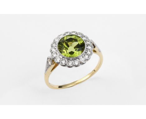 A PERIDOT AND DIAMOND CLUSTER RING the circular-cut peridot is set within a surround of circular-cut diamonds, with a further