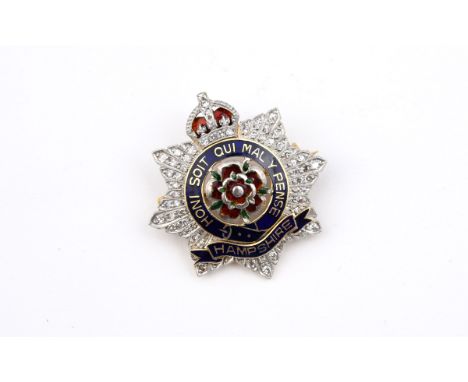 A DIAMOND AND ENAMEL REGIMENTAL BROOCH FOR THE ROYAL HAMPSHIRE REGIMENT set overall with single-cut diamonds, with red, green