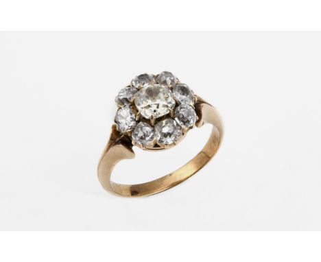 A DIAMOND CLUSTER RING the central cushion-shaped diamond is set within a surround of eight old-cut diamonds in yellow gold. 
