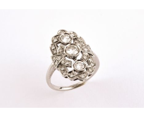 A DIAMOND CLUSTER RING the openwork design is mounted with three collet set circular-cut diamonds, within a surround of circu