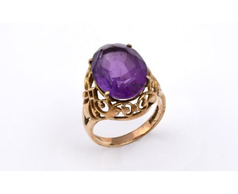 AN AMETHYST SINGLE STONE RING the oval-shaped amethyst is set in an 18ct gold openwork mount. Size L 1/2