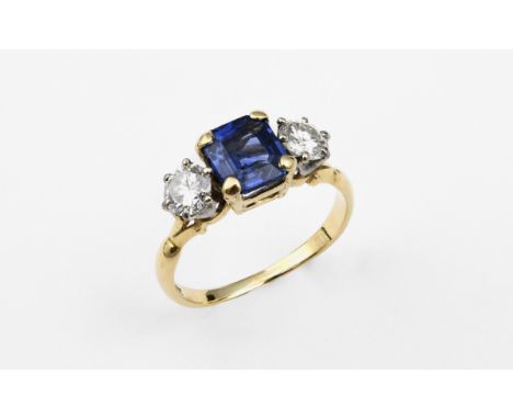 A SAPPHIRE AND DIAMOND THREE STONE RING the square-shaped sapphire is set with two brilliant-cut diamonds in 18ct yellow gold