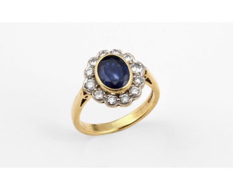 A SAPPHIRE AND DIAMOND CLUSTER RING the oval-shaped sapphire is set with a surround of circular-cut diamonds, in 18ct gold. S